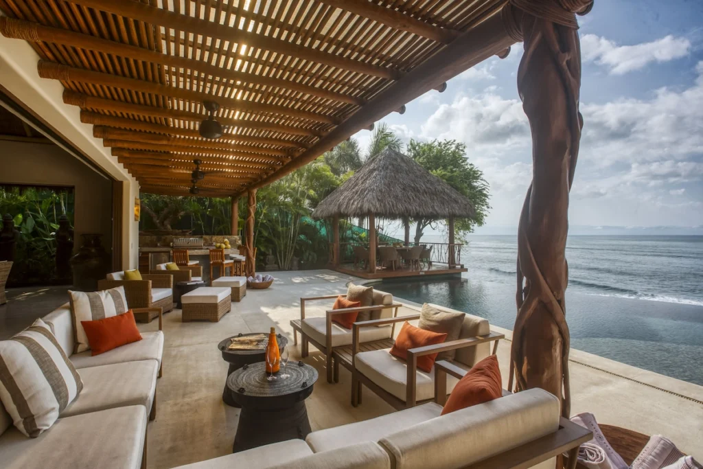 Covered terrace beside Casa Dewi's infinity pool overlooking the Pacific Ocean