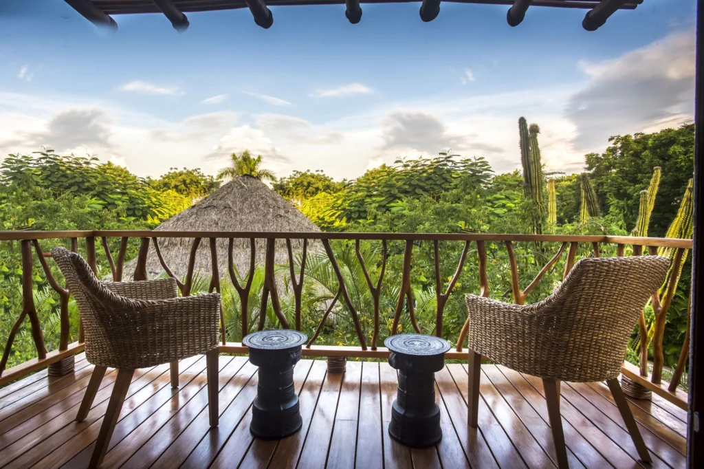 Private balcony at Casa Dewi with wicker chairs overlooking tropical greenery