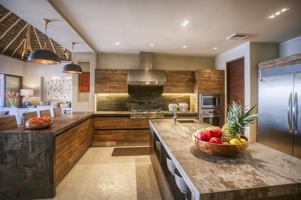 Casa Dewi kitchen with a stone island, wood cabinetry and stainless-steel appliances