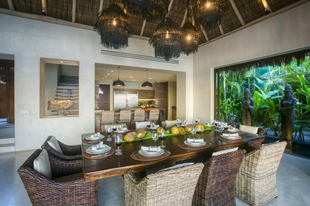 Dining table set for guests at Casa Dewi beside the kitchen and tropical garden