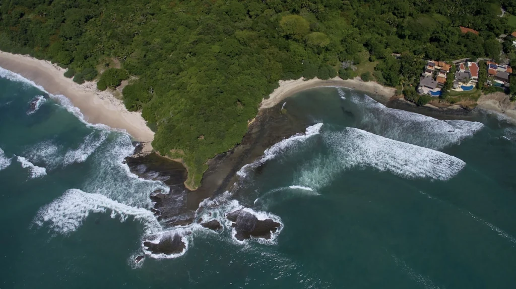 Aerial view of Casa Dewi above two sandy coves on the Pacific coast at Paradise Coves