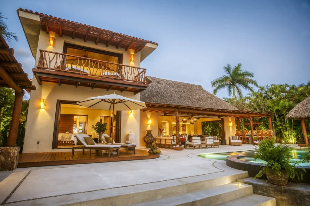 Casa Dewi pool courtyard at twilight with open living spaces and a private balcony