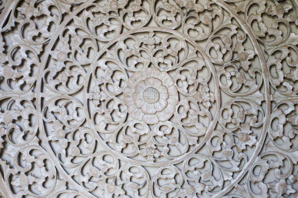 Intricate white carved floral medallion displayed at Casa Dewi