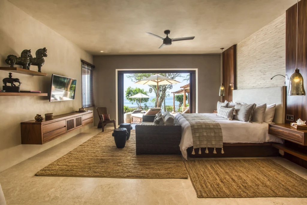 Spacious king suite at Casa Dewi opening to a furnished terrace with a Pacific Ocean view