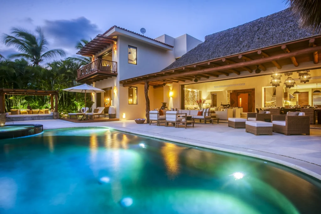 Casa Dewi pool terrace glowing at blue hour with open living and dining areas