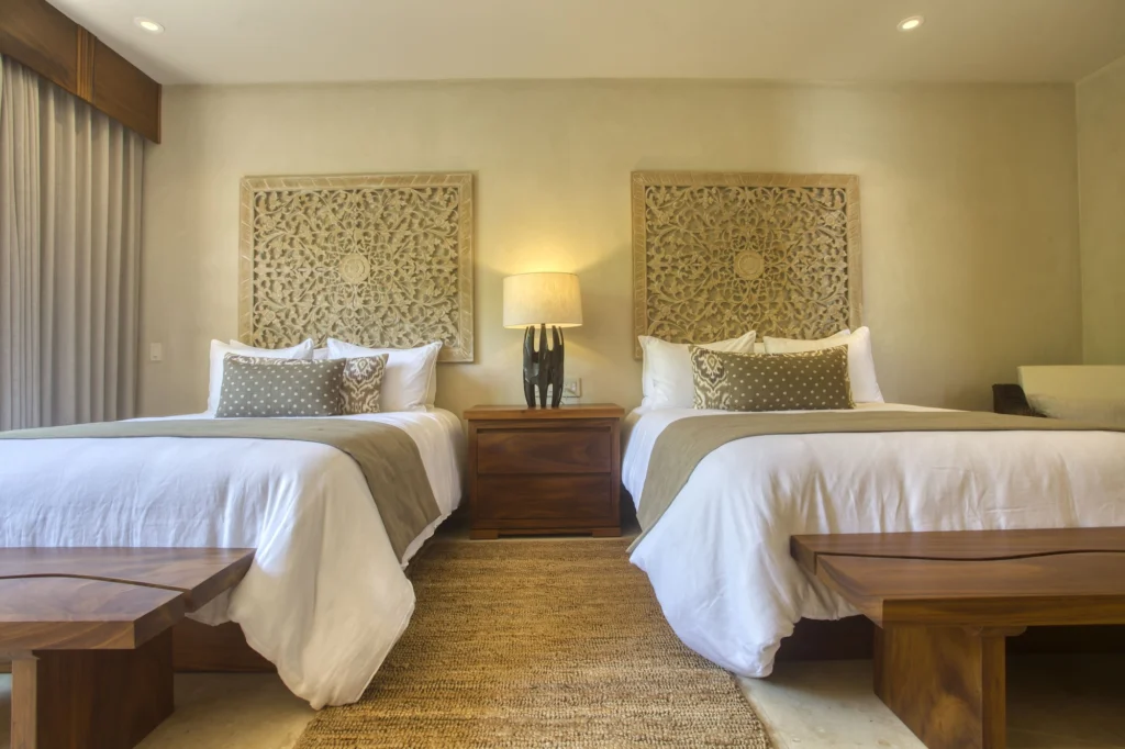 Guest bedroom at Casa Dewi with two beds and carved floral panels above the headboards