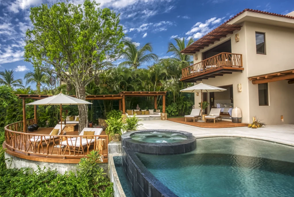 Casa Dewi pool courtyard with circular spa, shaded loungers, balconies and tropical landscaping